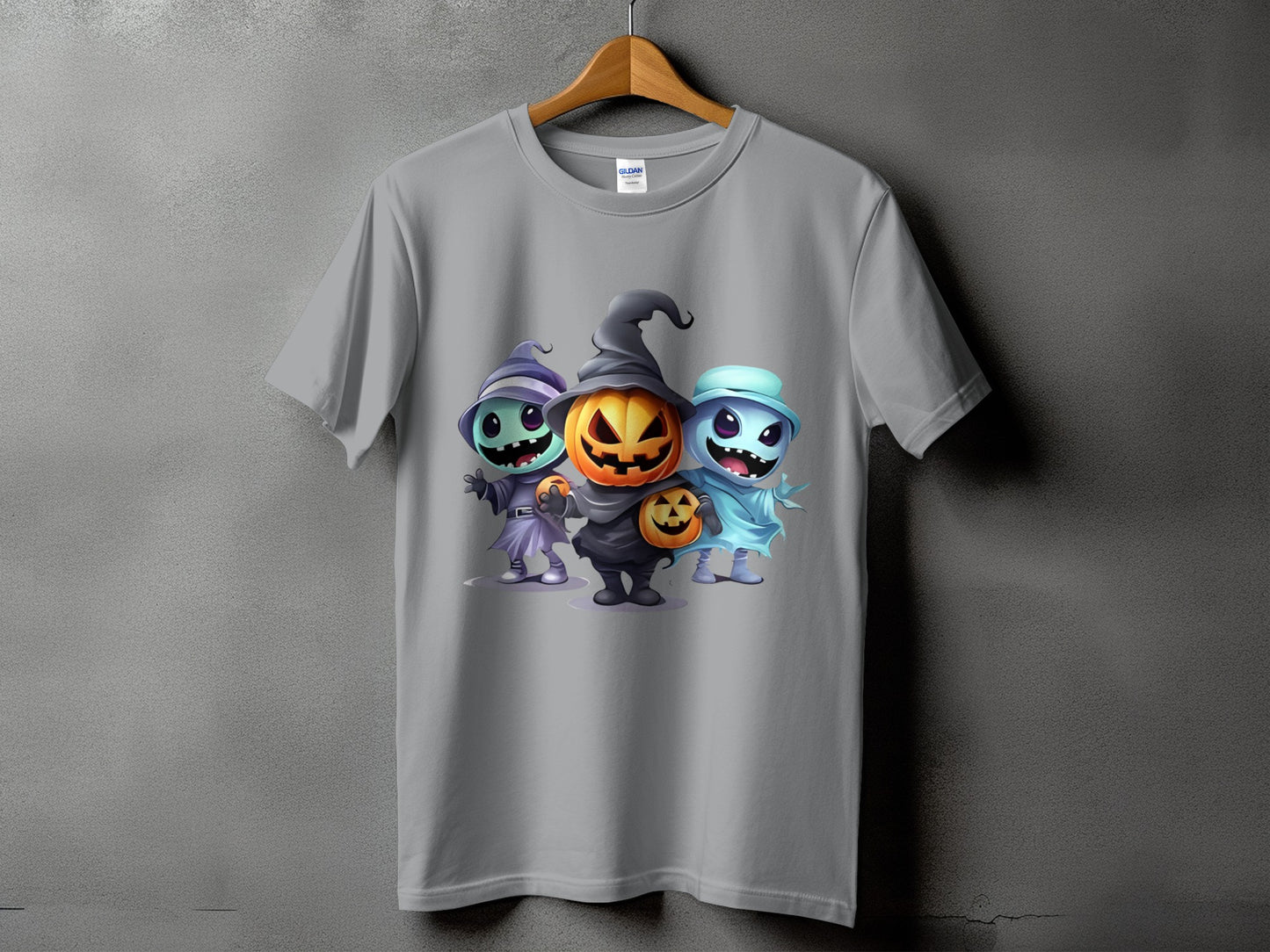 T-shirt with graphic of three cartoon Halloween monsters: pumpkin, ghost, and witch.