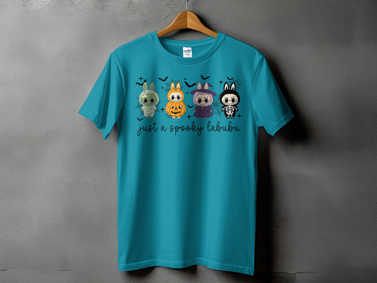 Teal t-shirt with four Halloween-themed cartoon characters and text "just a spooky labubu".