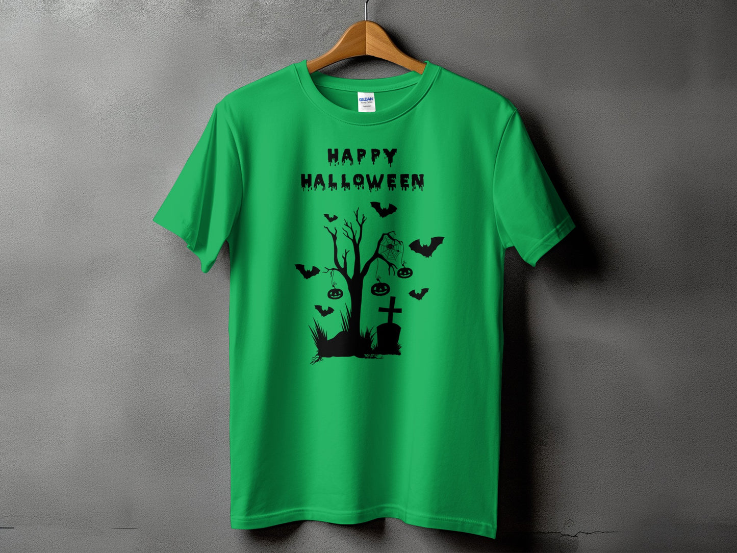 Green t-shirt with black Halloween graphic: Happy Halloween text, haunted tree, tombstone, bats, and pumpkins.