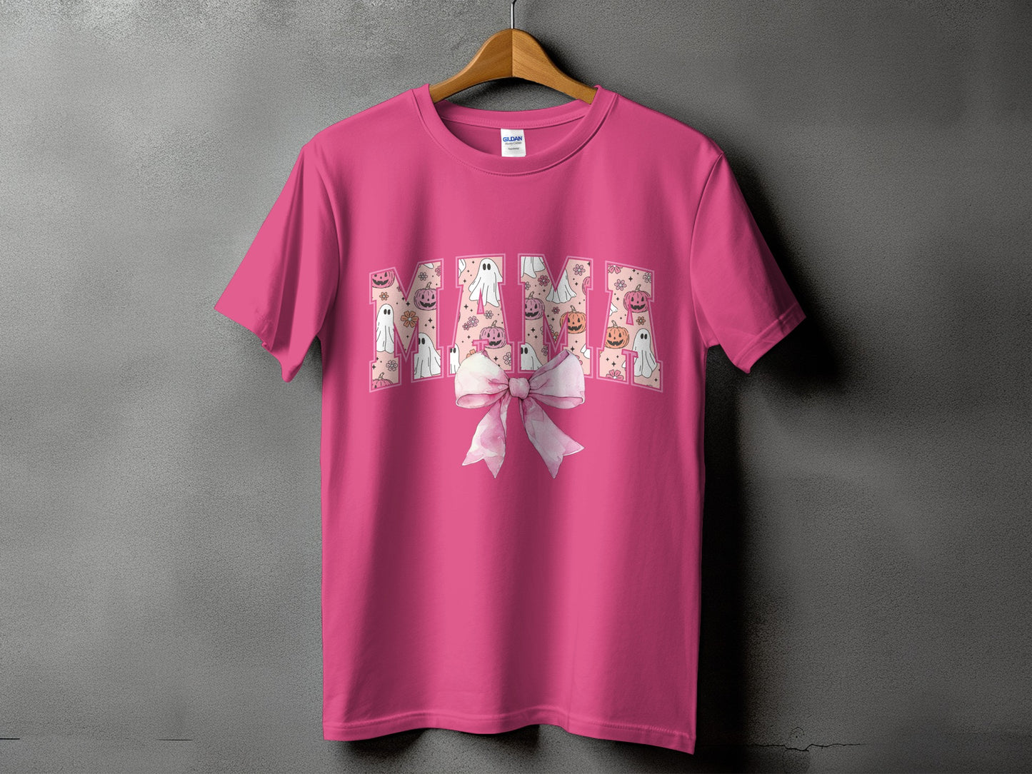 Pink t-shirt with "Mama" text in Halloween pattern and pink bow.