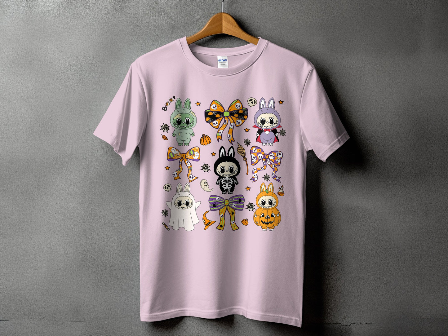 Pink t-shirt with a repeating pattern of cute Halloween characters and bows.