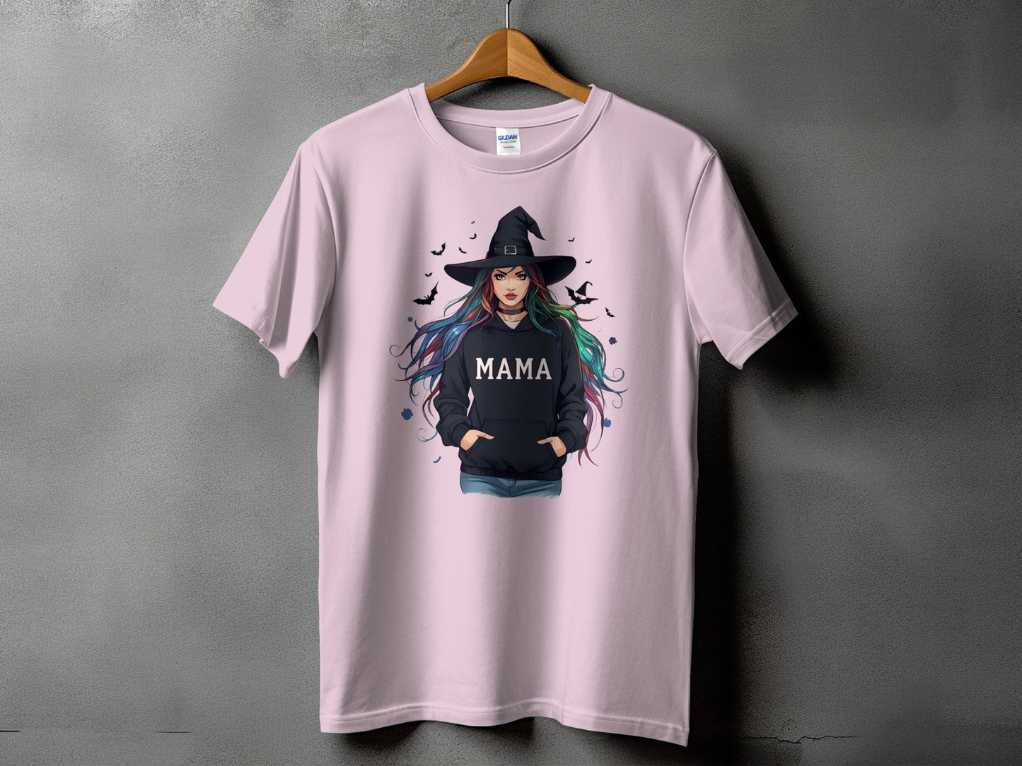 Pink t-shirt with graphic of a witch wearing a black hoodie with the word "MAMA".