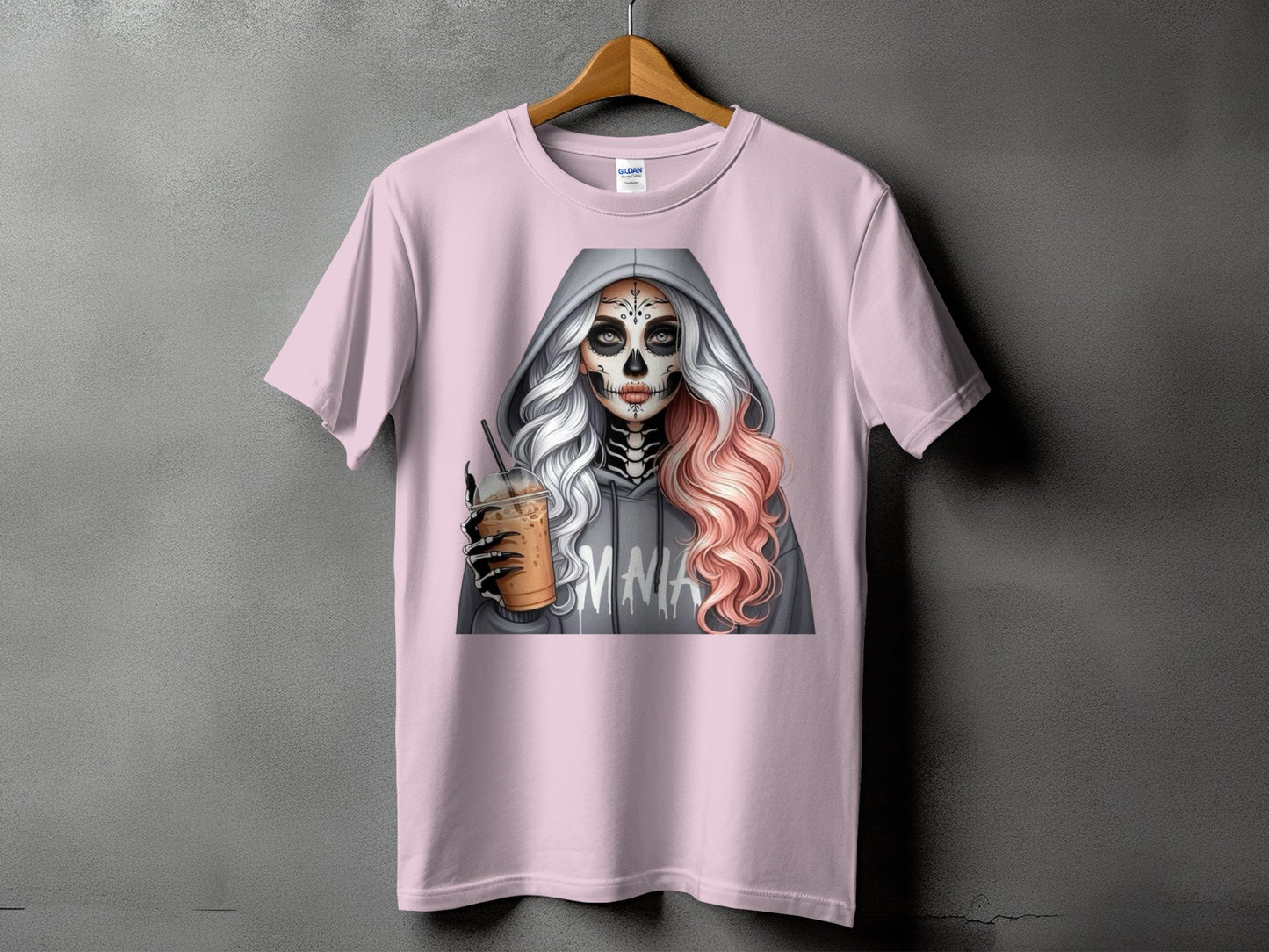 Pink t-shirt with skull makeup woman holding iced coffee and wearing a grey hoodie with "EMNA" printed on it.