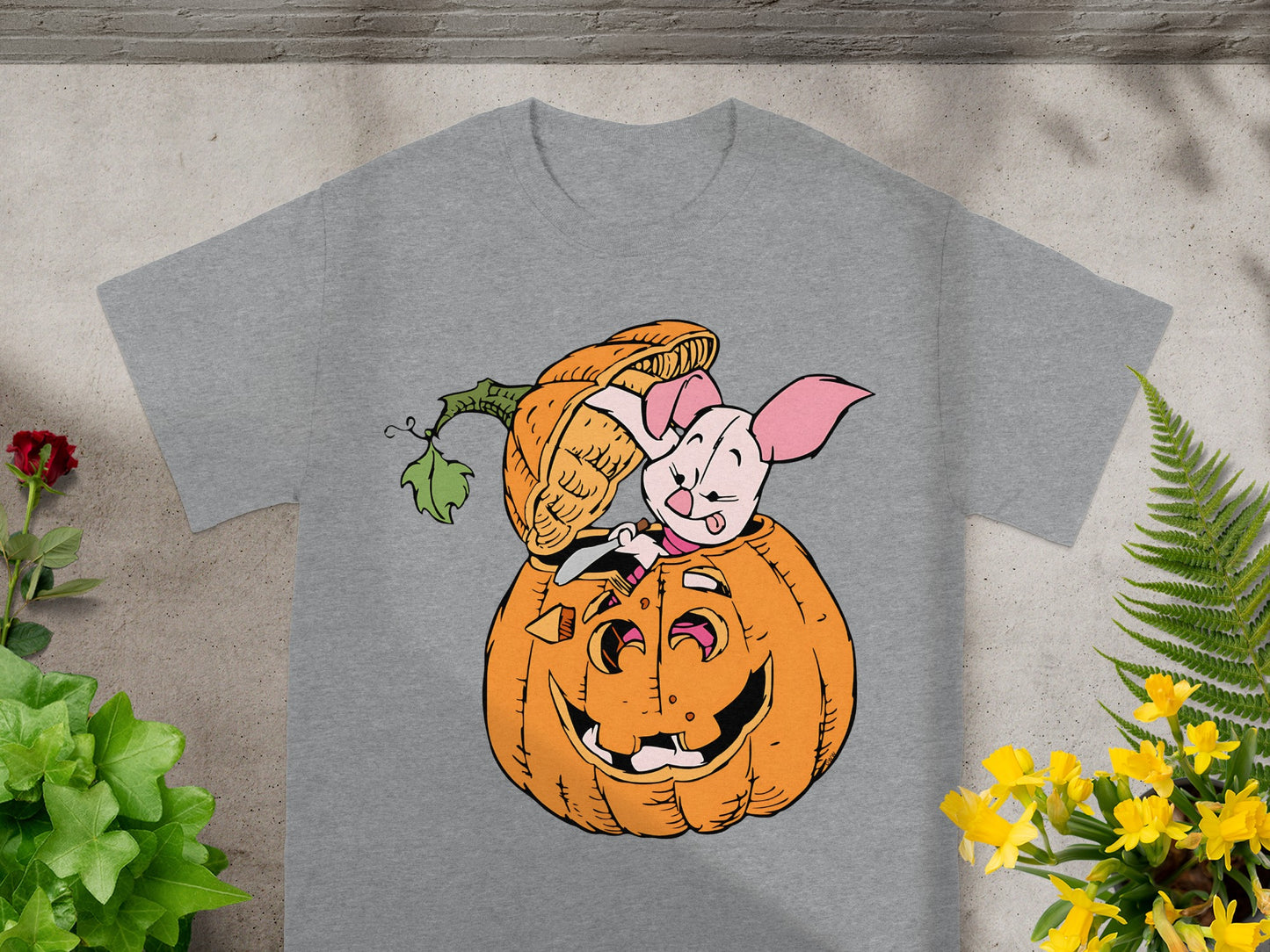 Piglet peeking out of a carved pumpkin on a gray t-shirt.