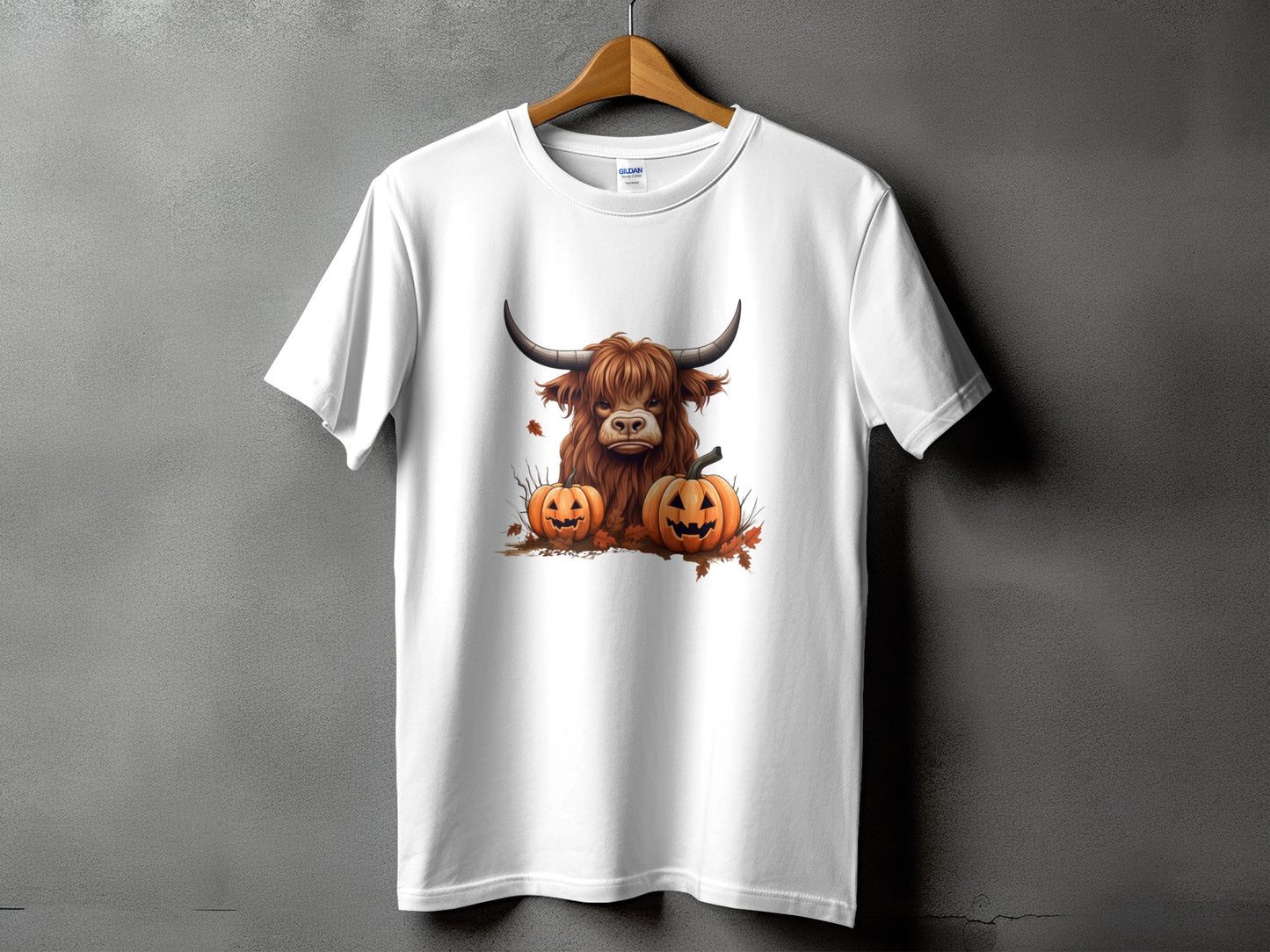 White t-shirt with a Halloween-themed print of a Highland cow and pumpkins.