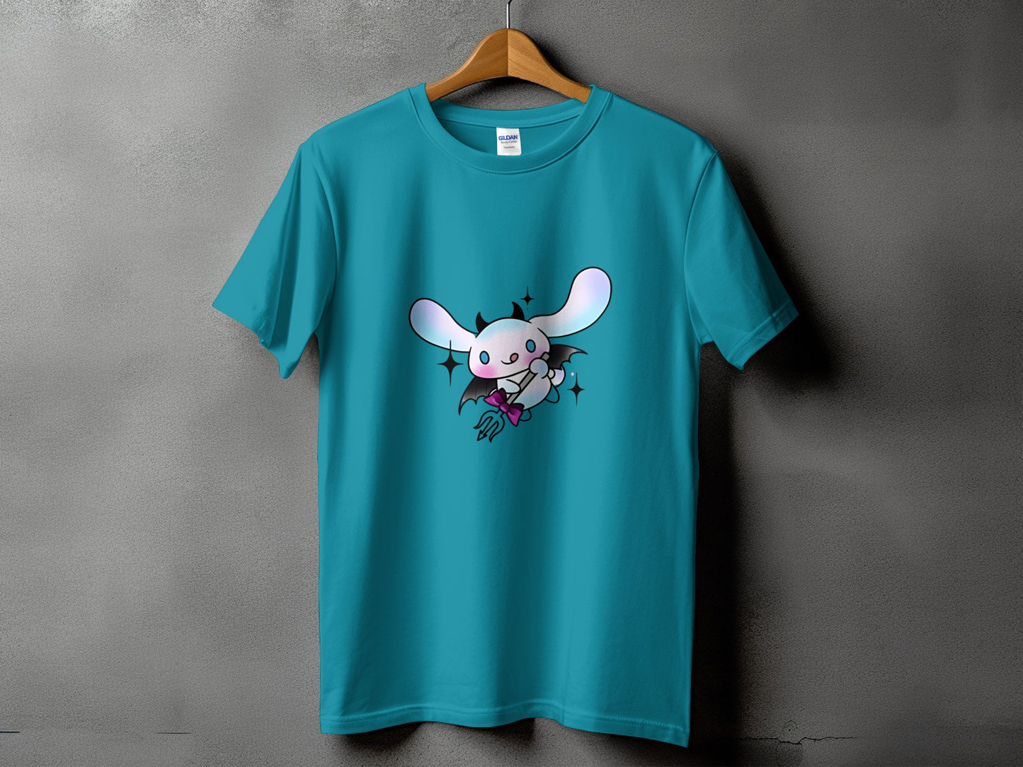 Teal t-shirt with a cute devil bunny graphic wearing a pink bow and holding a trident.