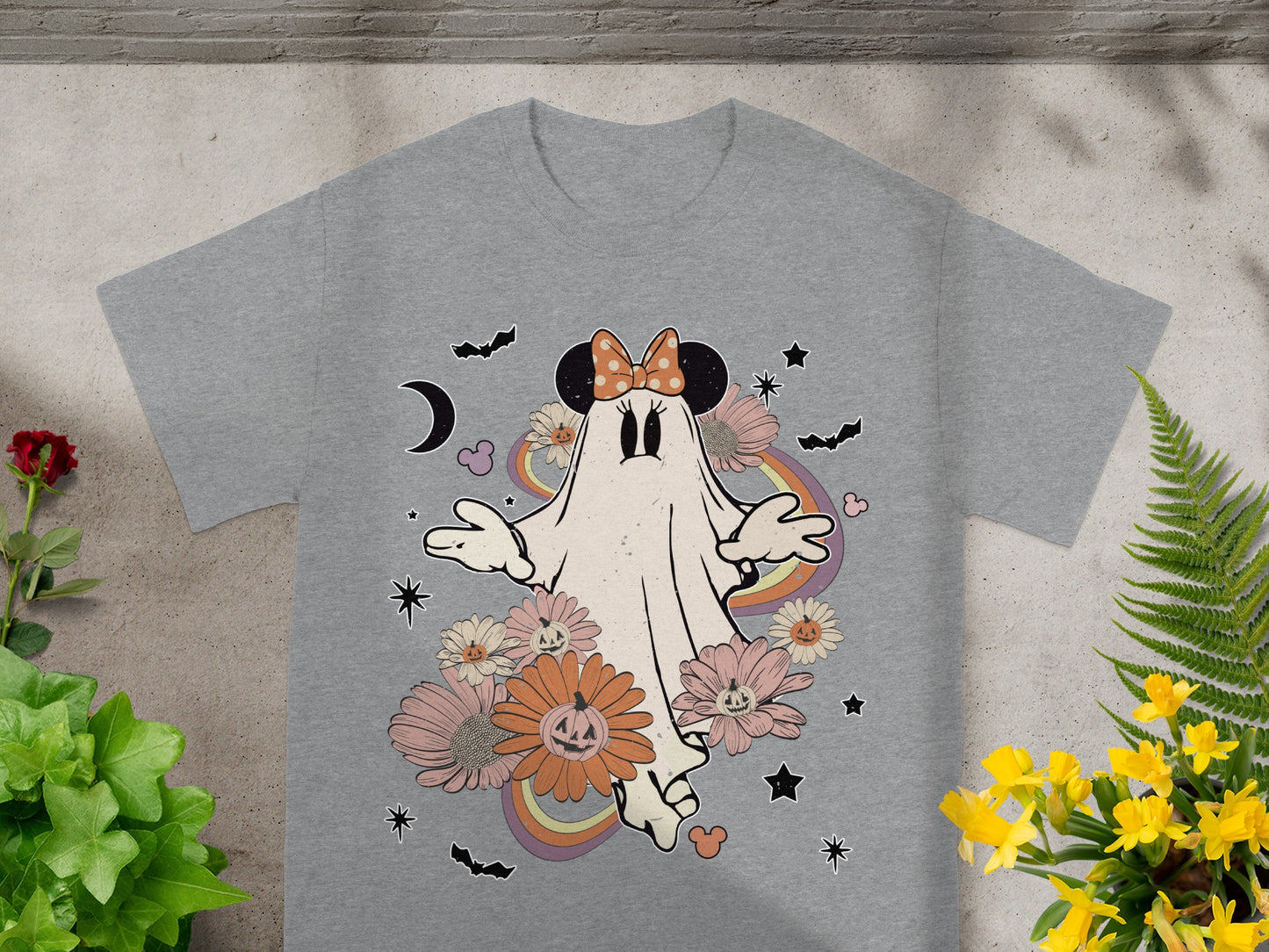 Ghost character in a Minnie Mouse bow surrounded by Halloween flowers and bats.