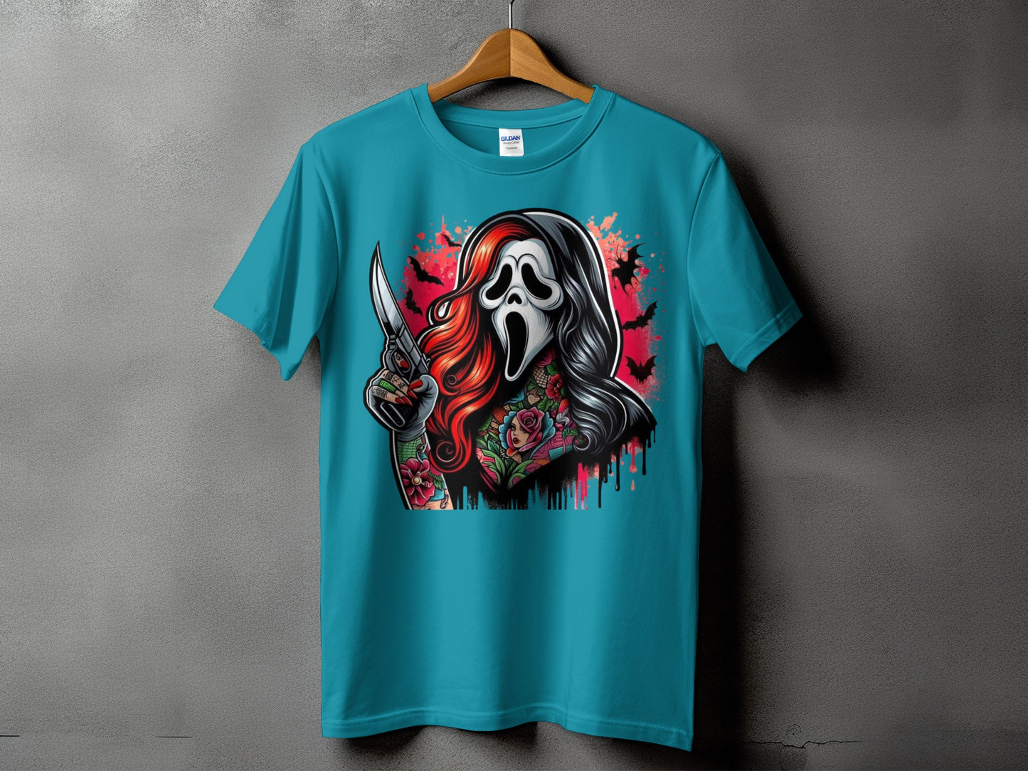 Teal t-shirt with a horror mask and knife graphic, featuring tattoos and bats.