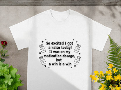 White t-shirt with "So excited I got a raise today! It was on my medication dosage, but a win is a win" text.