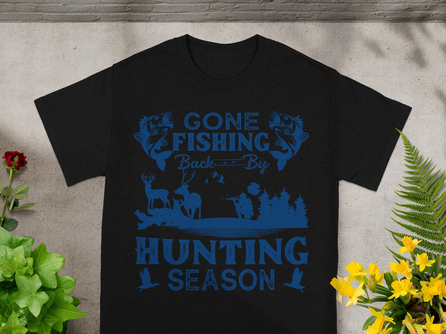 Black t-shirt with blue graphic text "GONE FISHING Back By HUNTING SEASON" and hunting imagery.