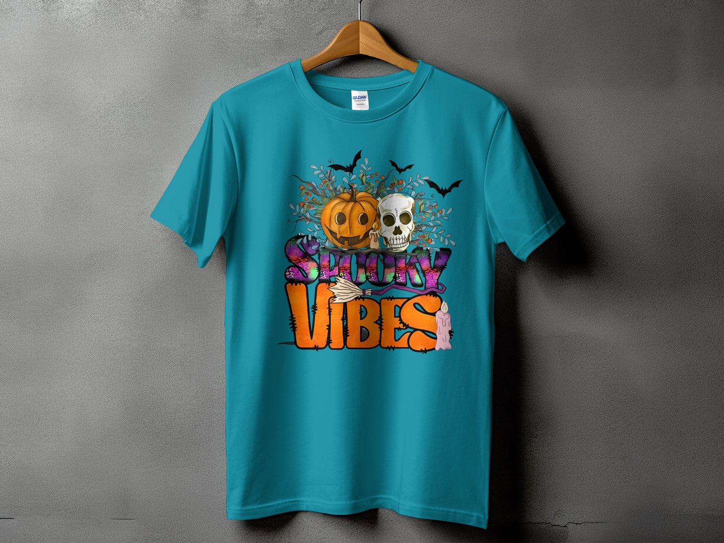 Teal t-shirt with "Spooky Vibes" Halloween graphic featuring pumpkin, skull, bats, and candle.