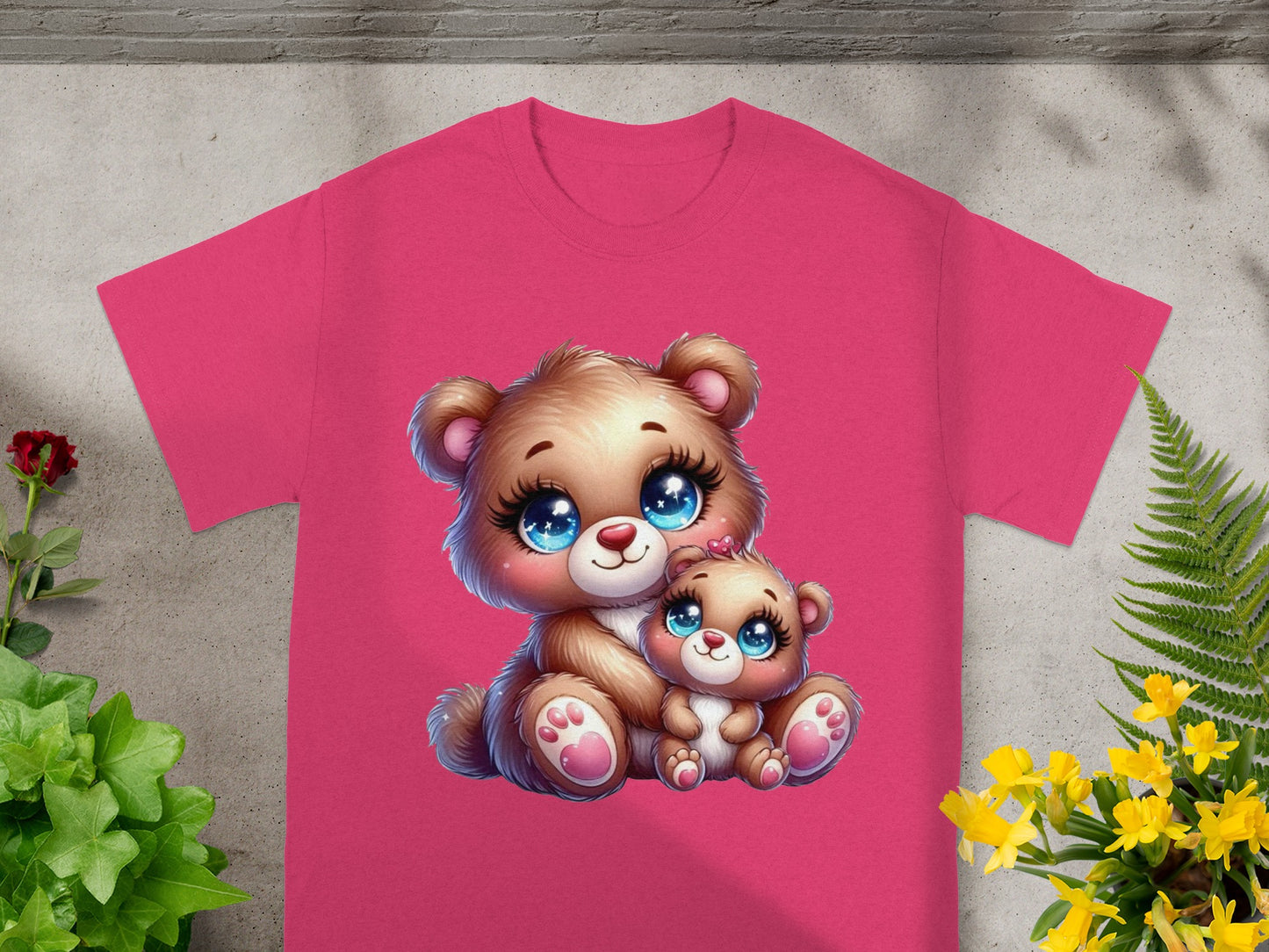 Two cartoon teddy bears, one large and one small, sitting together on a pink t-shirt.