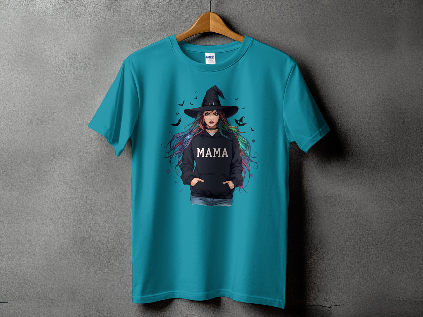Teal t-shirt featuring a witch with colorful hair and "MAMA" on her hoodie.