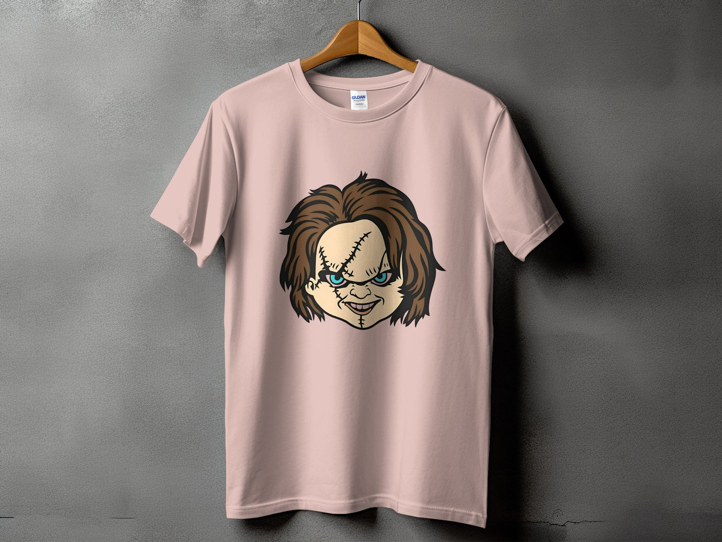 Pink t-shirt with Chucky doll face graphic on front.