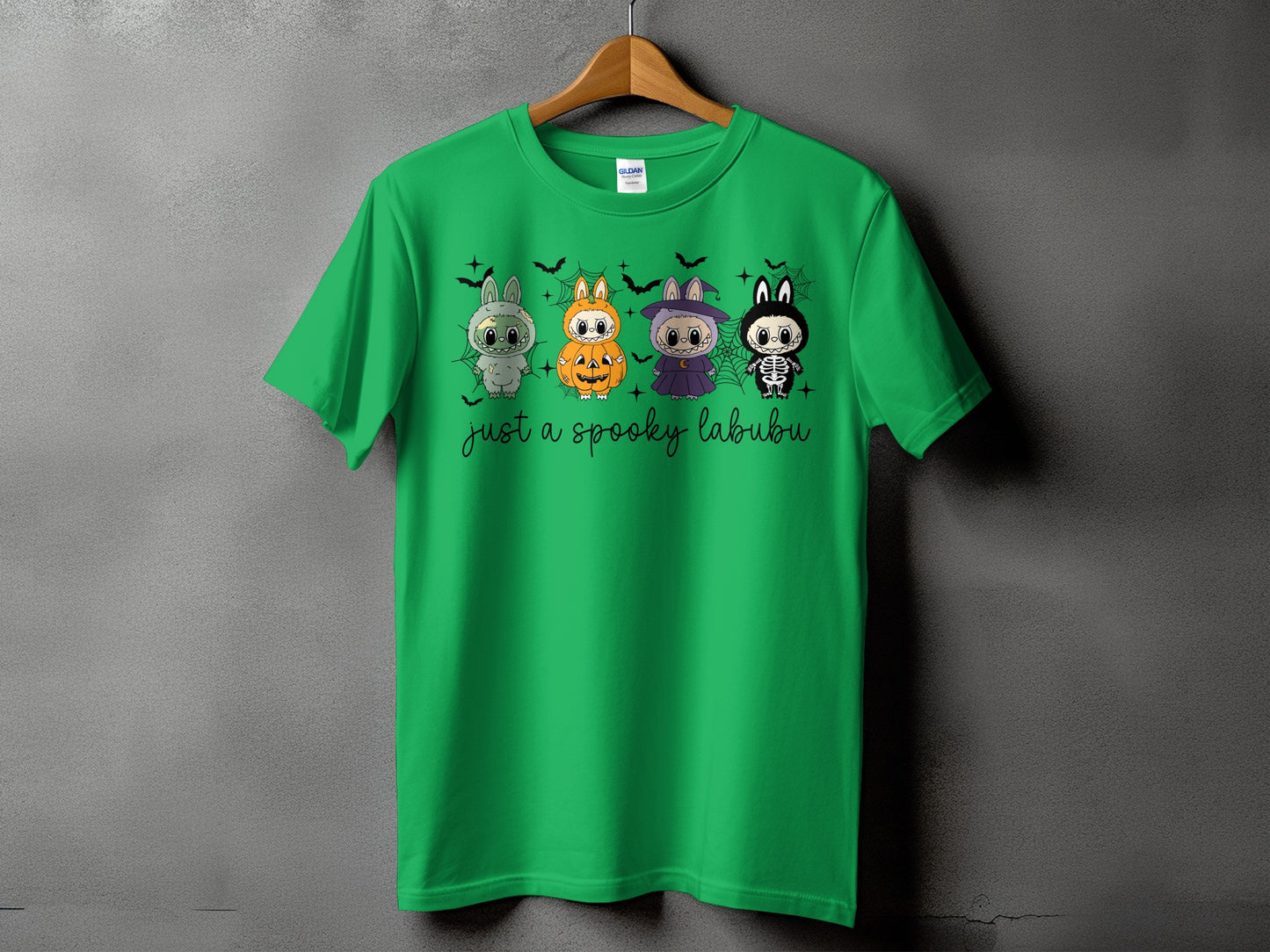 Green t-shirt with four Halloween-themed cartoon bunnies and "just a spooky labubu" text.