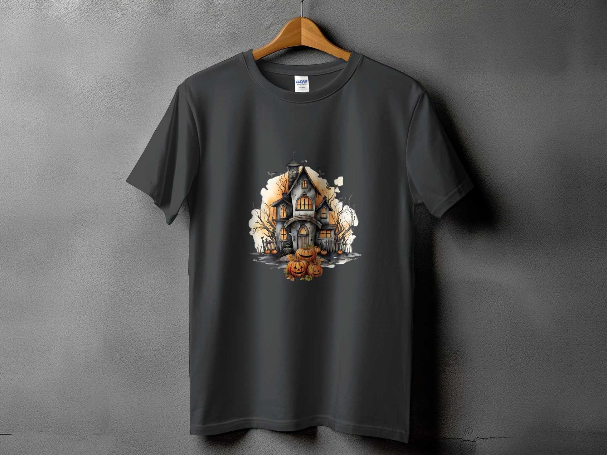 Dark grey t-shirt with a watercolor graphic of a haunted house and pumpkins.