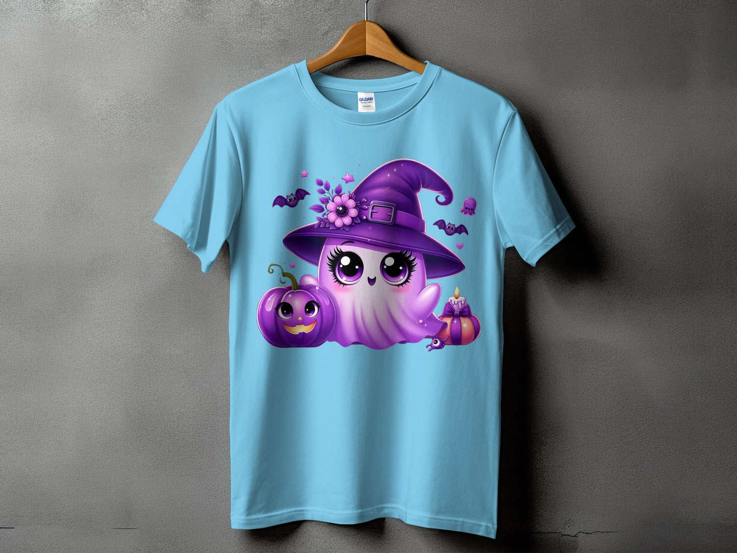 Light blue t-shirt with a cute purple ghost wearing a witch hat and surrounded by Halloween elements.