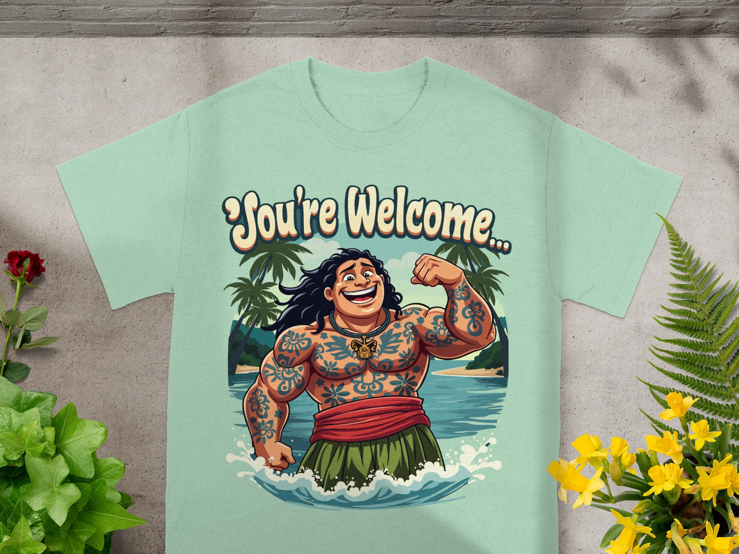 Mint green t-shirt with cartoon man flexing, "You're Welcome" text, and tropical background.