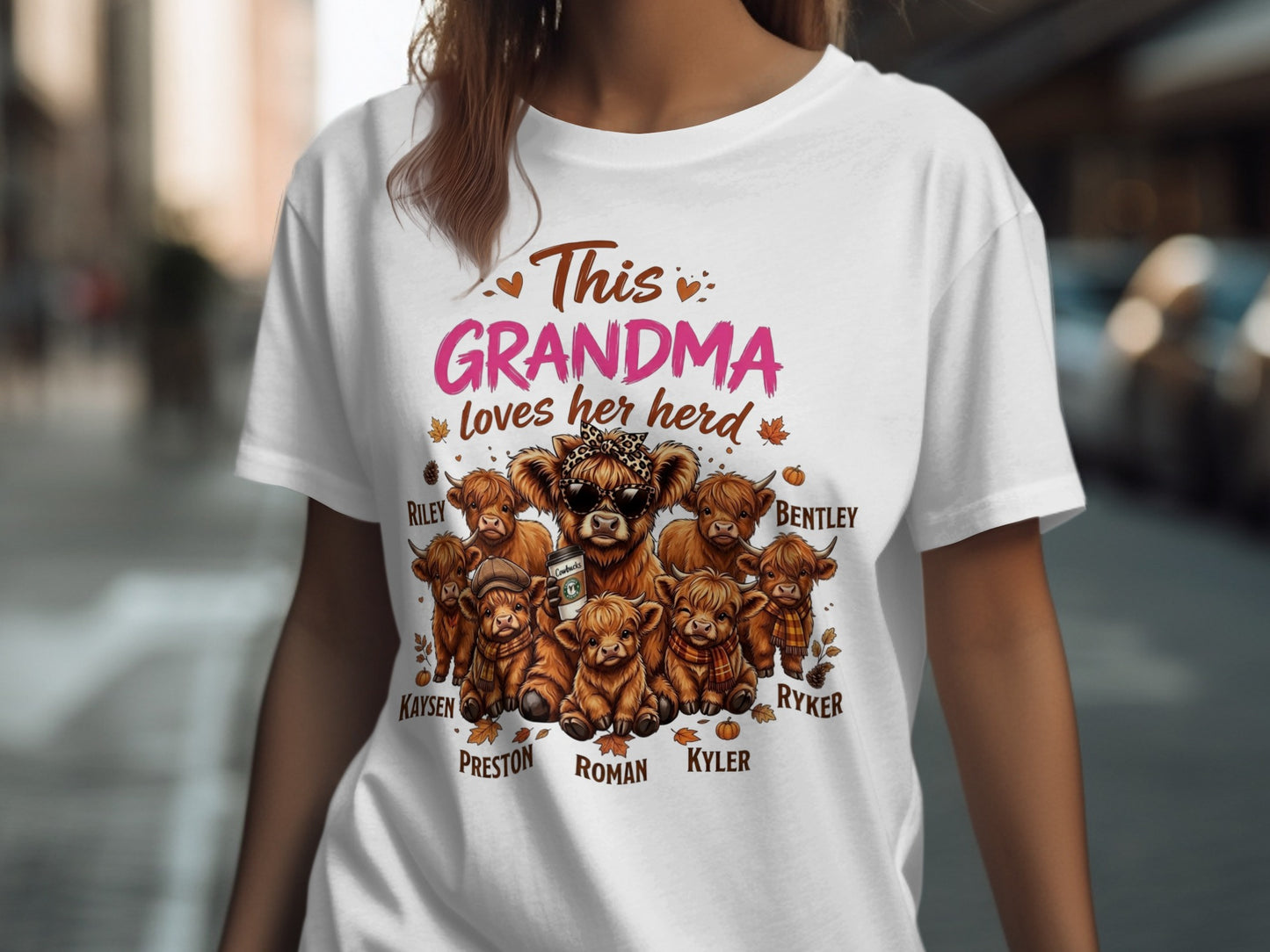 White t-shirt with "This Grandma loves her herd" and Highland cows, names Riley, Bentley, Kaysen, Preston, Roman, Kyler, Ryker.
