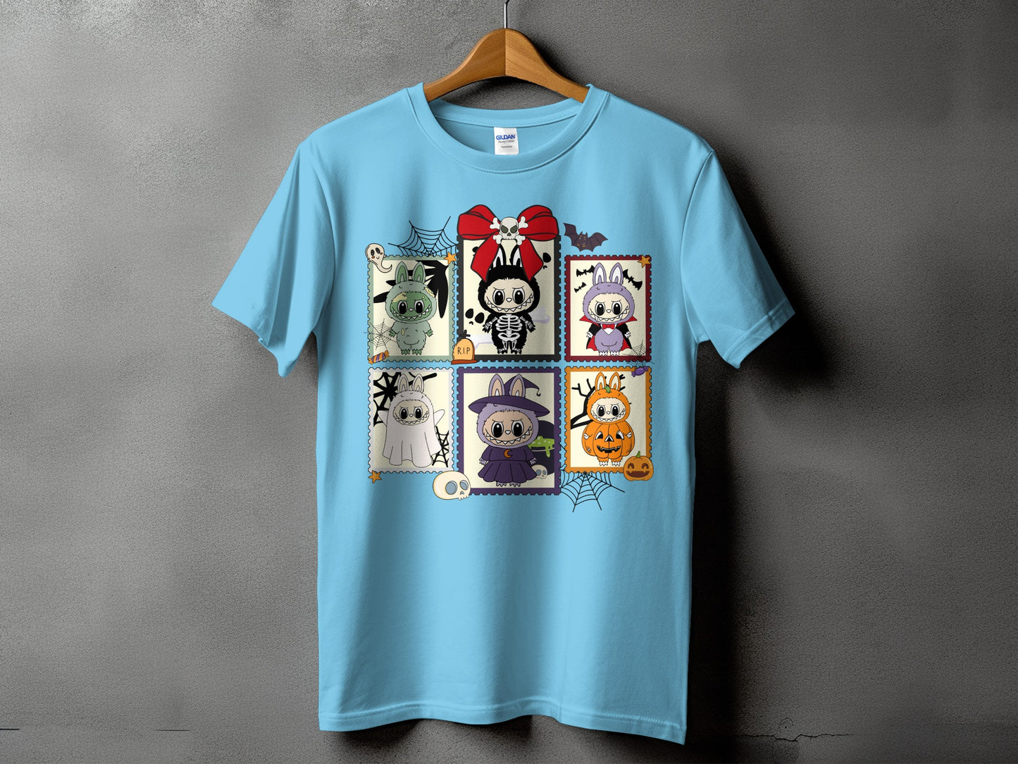 Light blue t-shirt with a grid of six Halloween-themed cartoon characters.