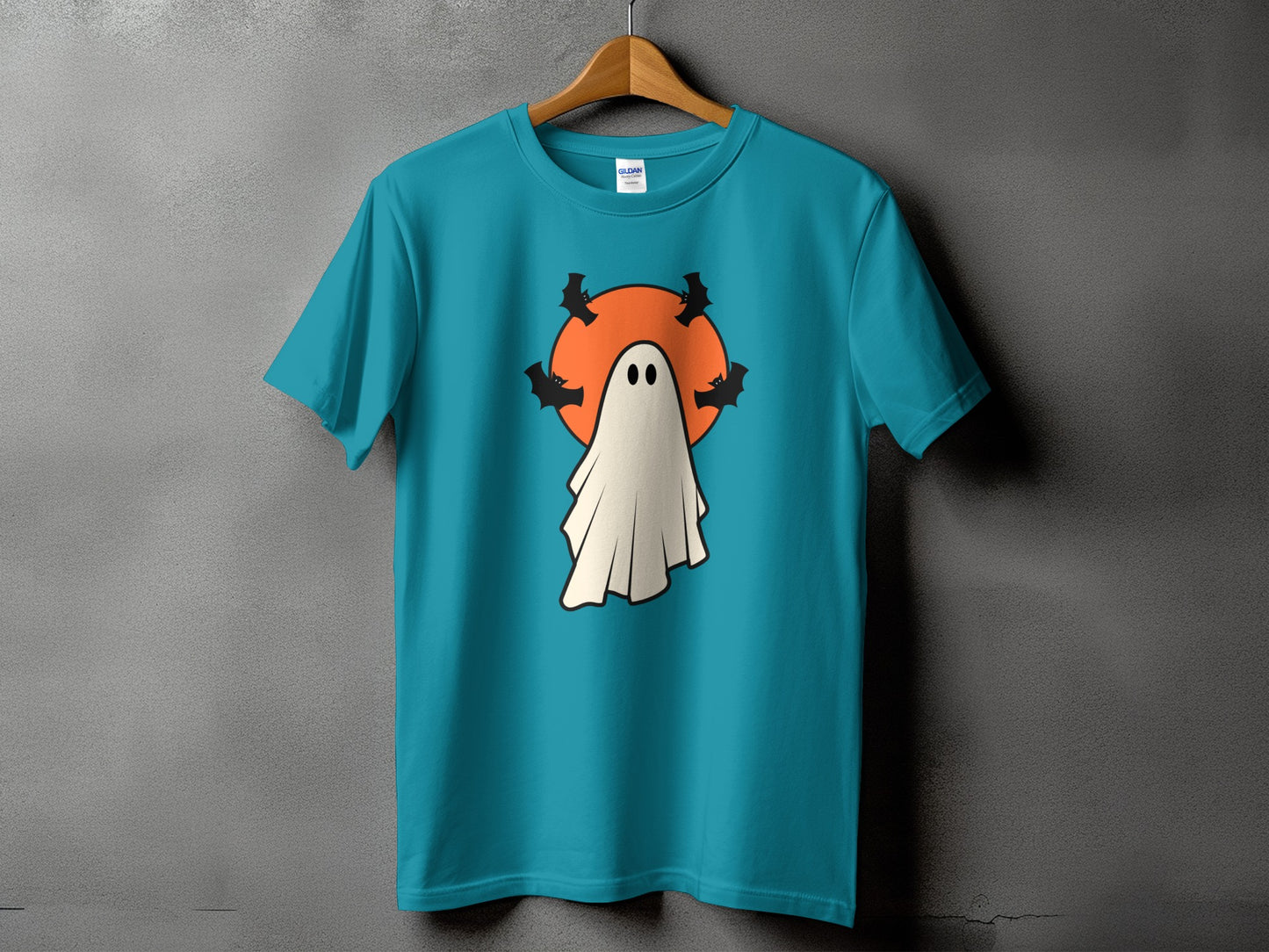 Teal t-shirt with a ghost, bats, and orange circle Halloween graphic.