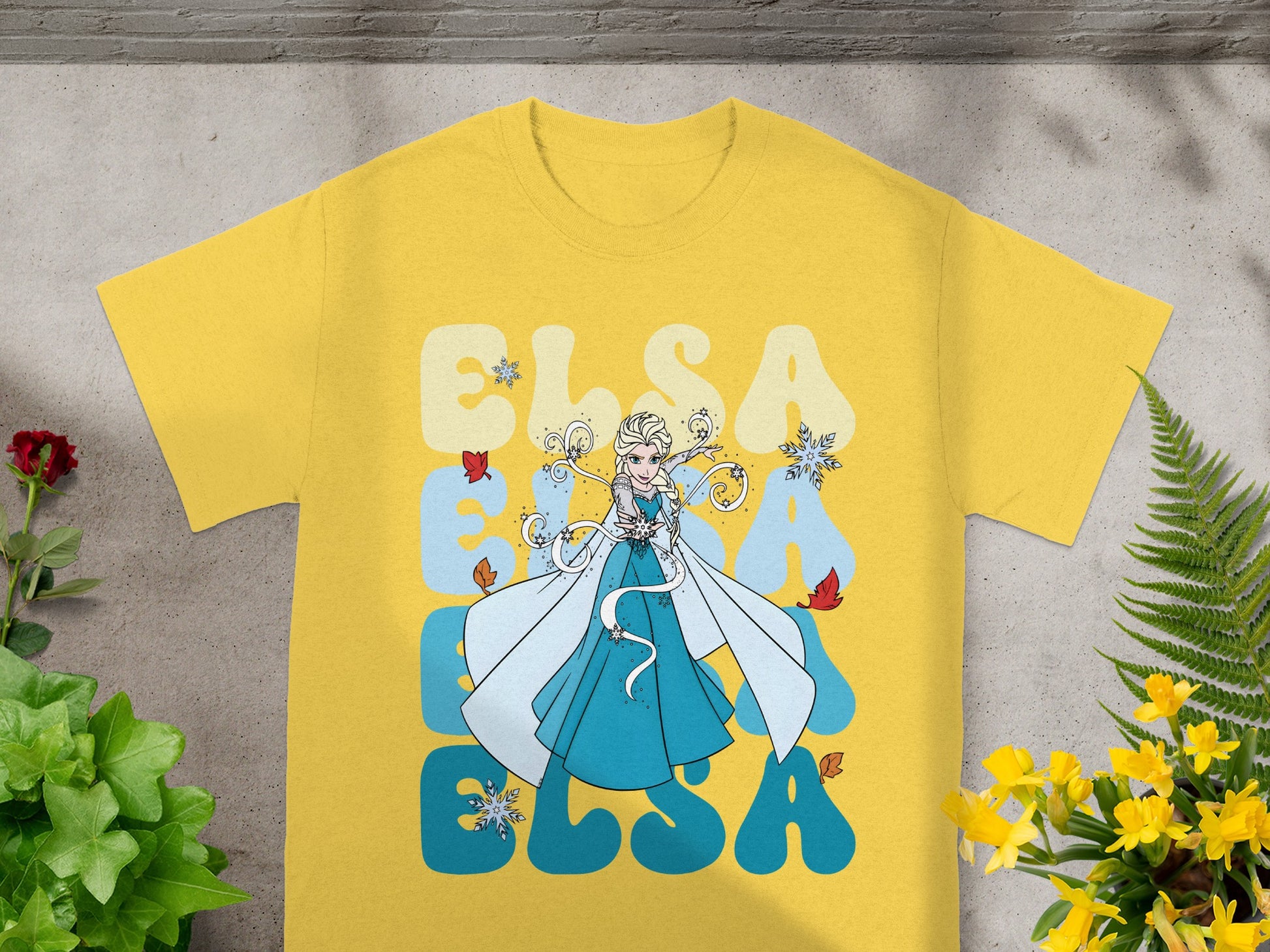 Yellow t-shirt with Elsa from Frozen graphic and text.