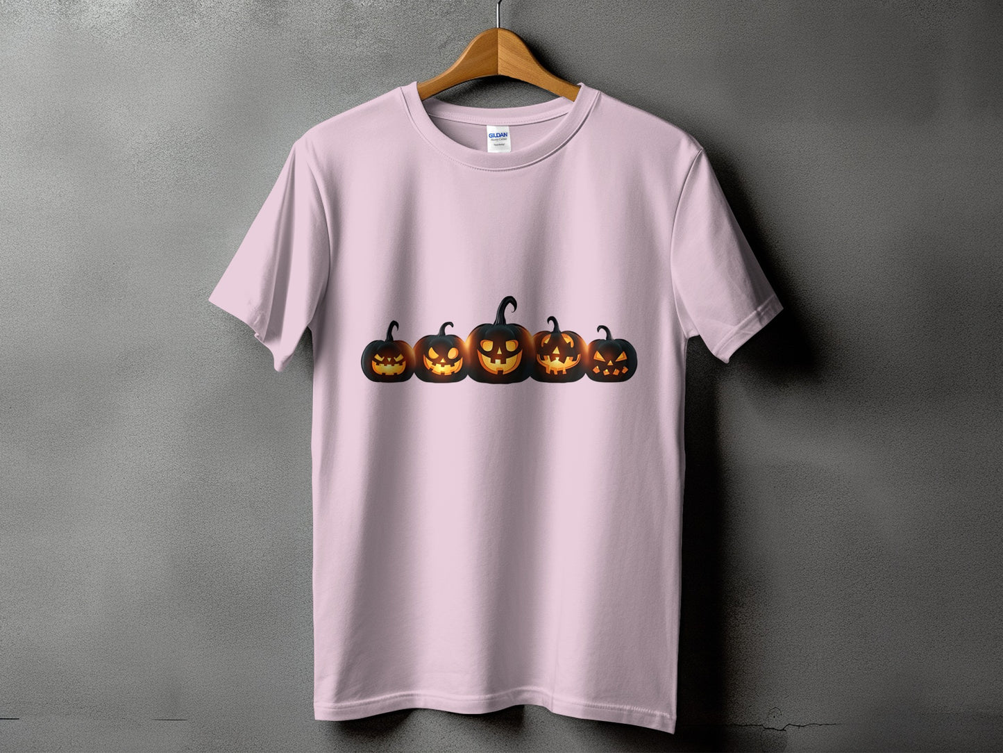 Pink t-shirt with a row of five glowing jack-o'-lanterns across the chest.