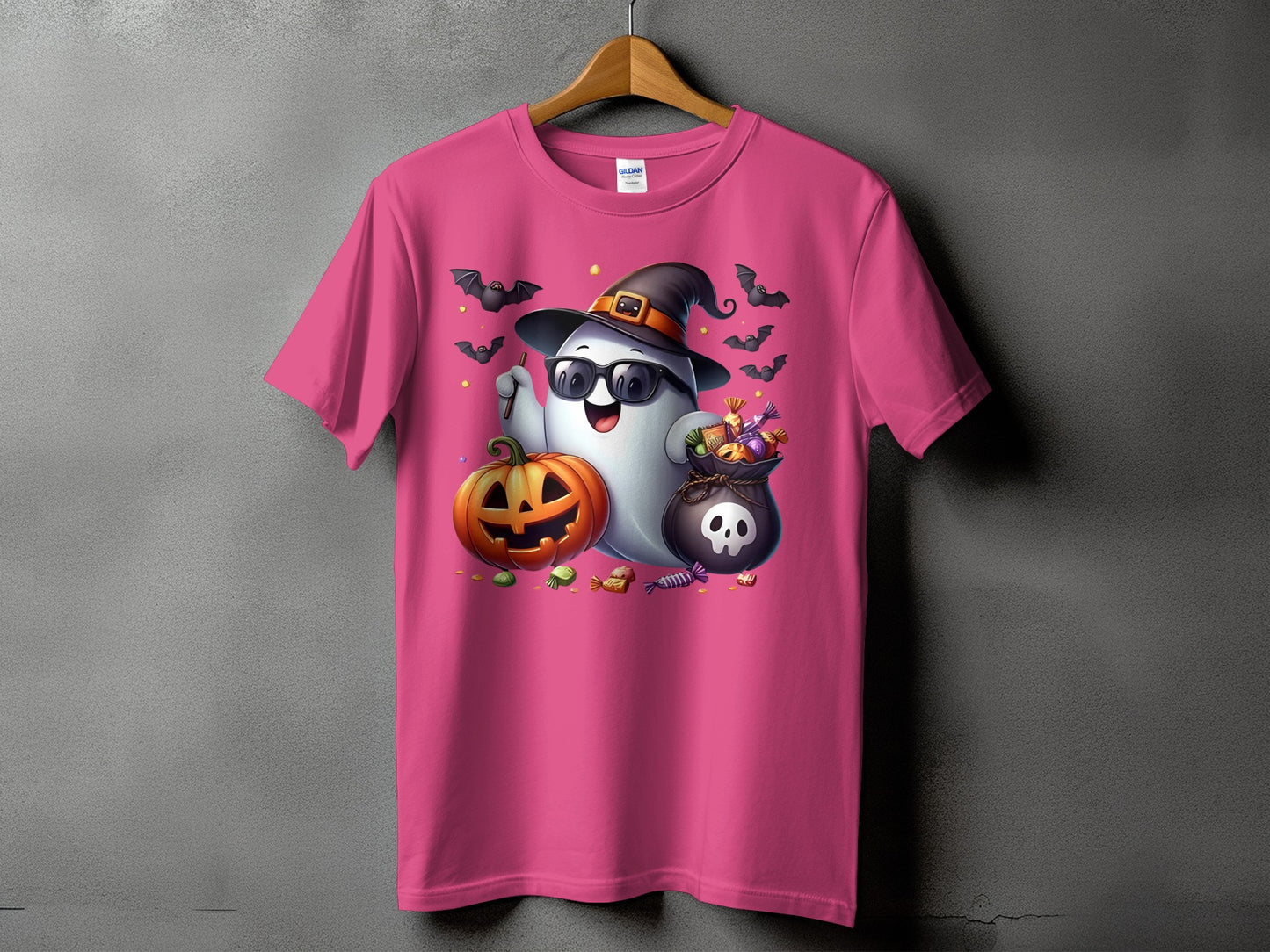 Pink t-shirt with a cartoon ghost wearing a witch hat, sunglasses, holding candy and a pumpkin.