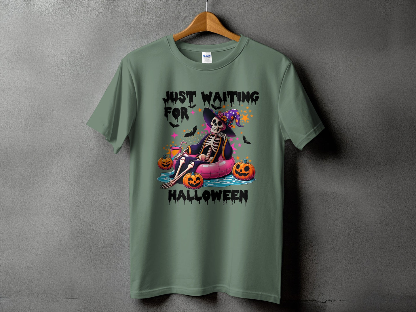 Green t-shirt with "Just Waiting for Halloween" text and skeleton on inflatable.