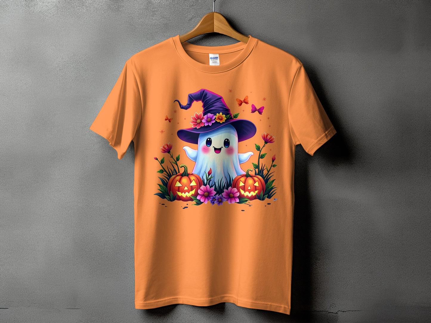 Orange t-shirt with a cartoon ghost in a witch hat and jack-o-lanterns.