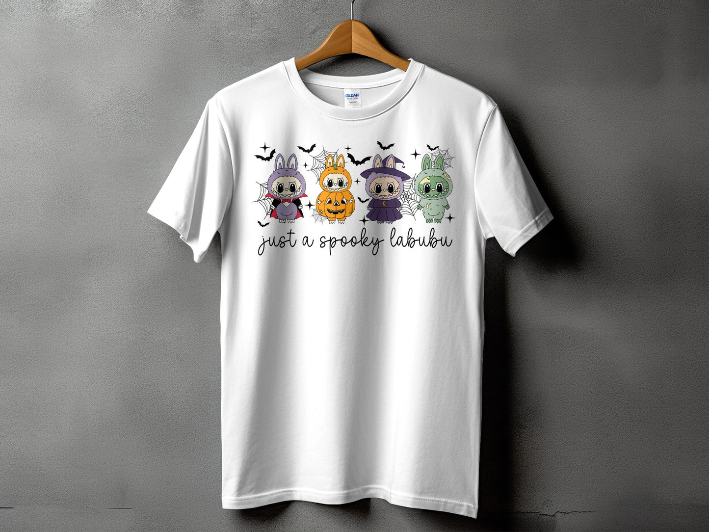 White t-shirt with four Halloween-themed cartoon characters and "just a spooky labubu" text.
