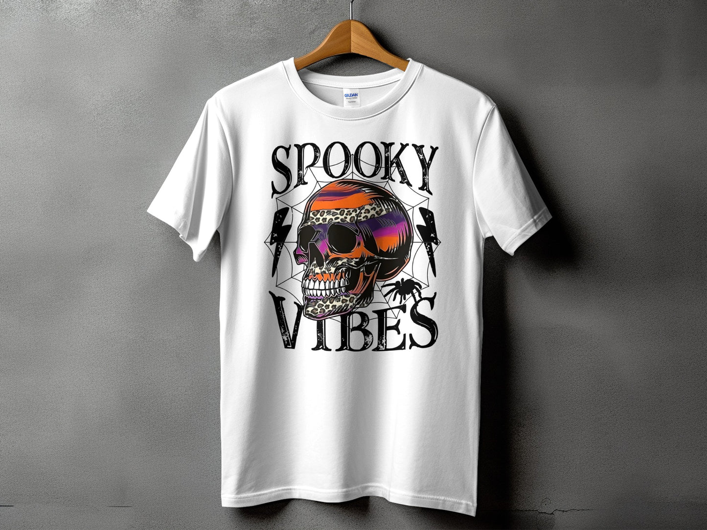 White t-shirt with "SPOOKY VIBES" text, a colorful skull, and a spider.