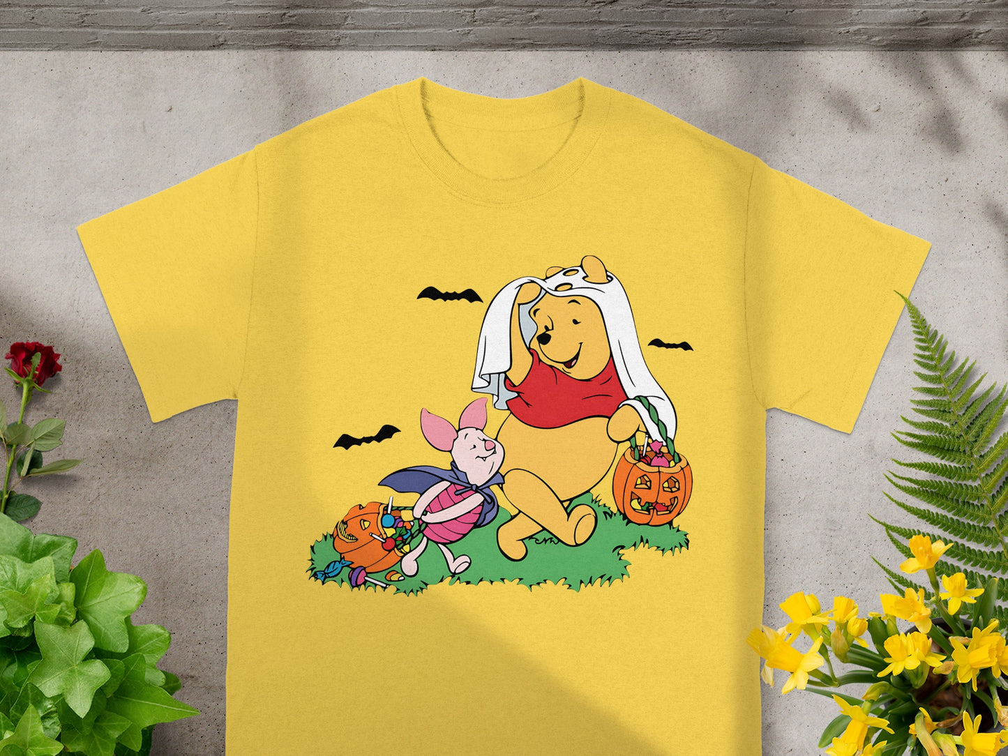 Winnie the Pooh and Piglet in Halloween costumes with candy and pumpkins.