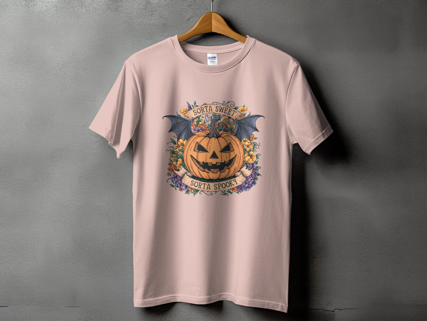 Pink t-shirt with jack-o'-lantern, bat wings, flowers, and text "Sorta Sweet Sorta Spooky".