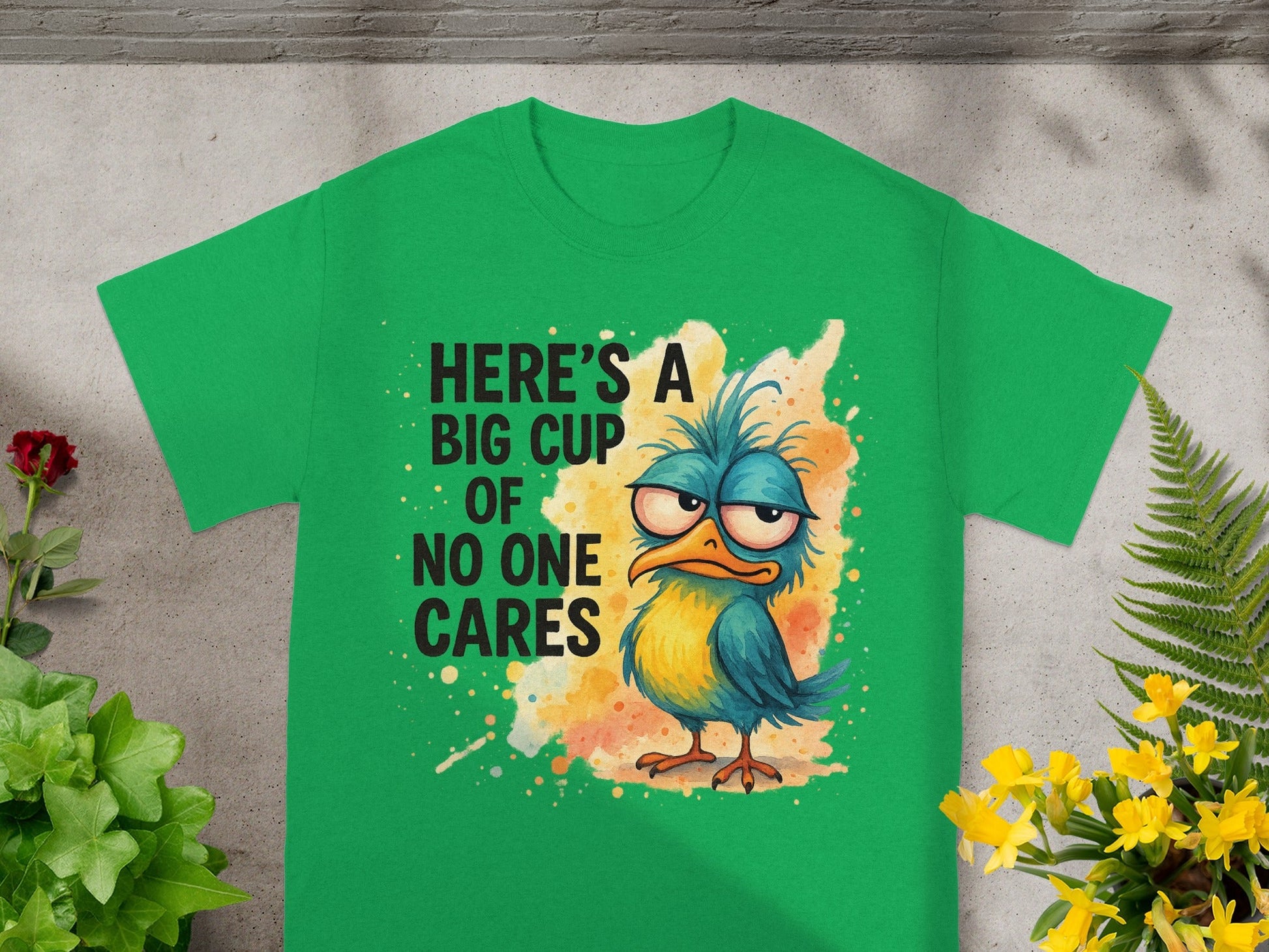 Green t-shirt with grumpy bird and text: "Here's a big cup of no one cares".