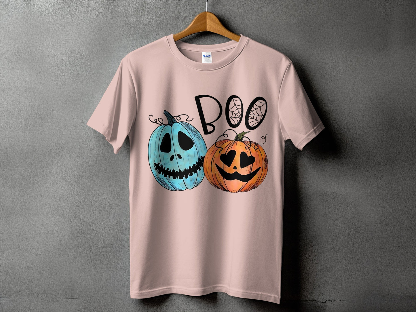 Pink t-shirt with "BOO" and two cartoon pumpkins for Halloween.