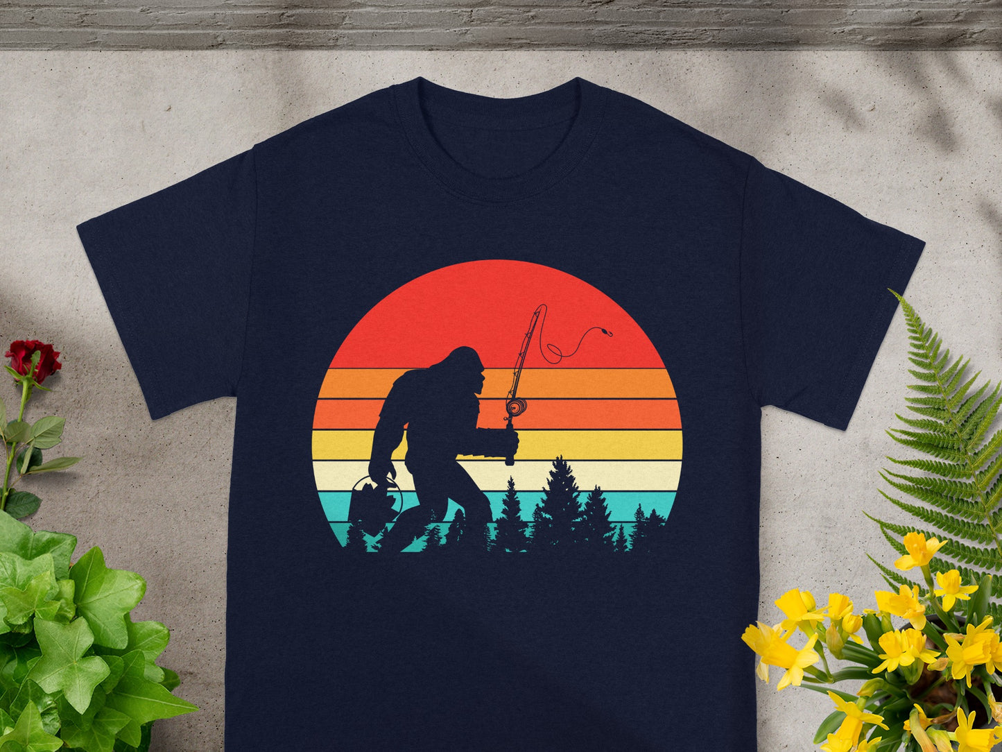 Bigfoot silhouette fishing in front of a retro sunset with trees.