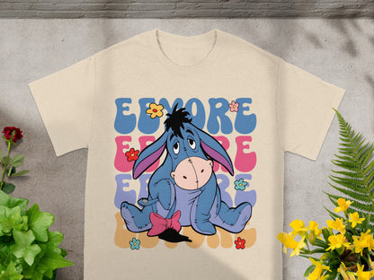 Eeyore with flowers graphic on a beige t-shirt.