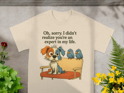 Cream t-shirt with dog and three birds saying "Oh, sorry. I didn't realize you're an expert in my life."