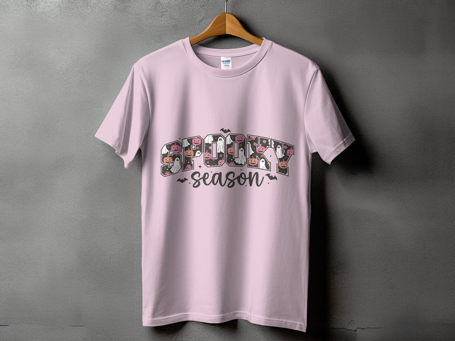 Pink t-shirt with "Spooky Season" text featuring Halloween icons.