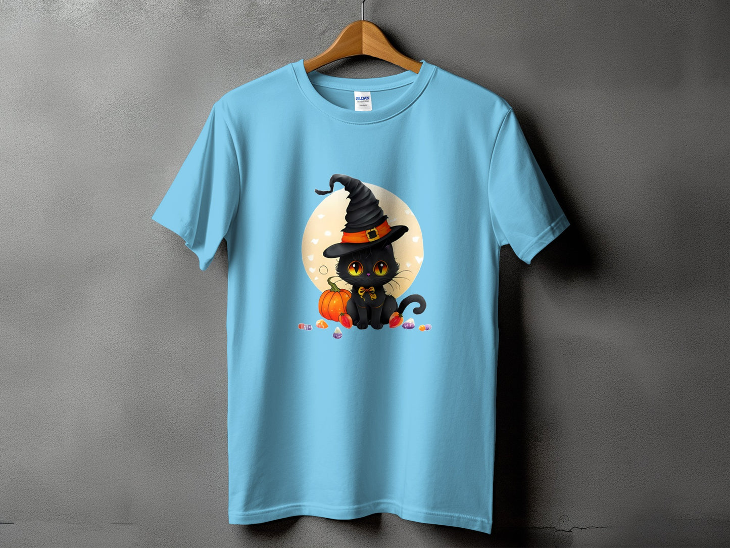 Light blue t-shirt with a black cat in a witch hat, pumpkin, and candy graphic.