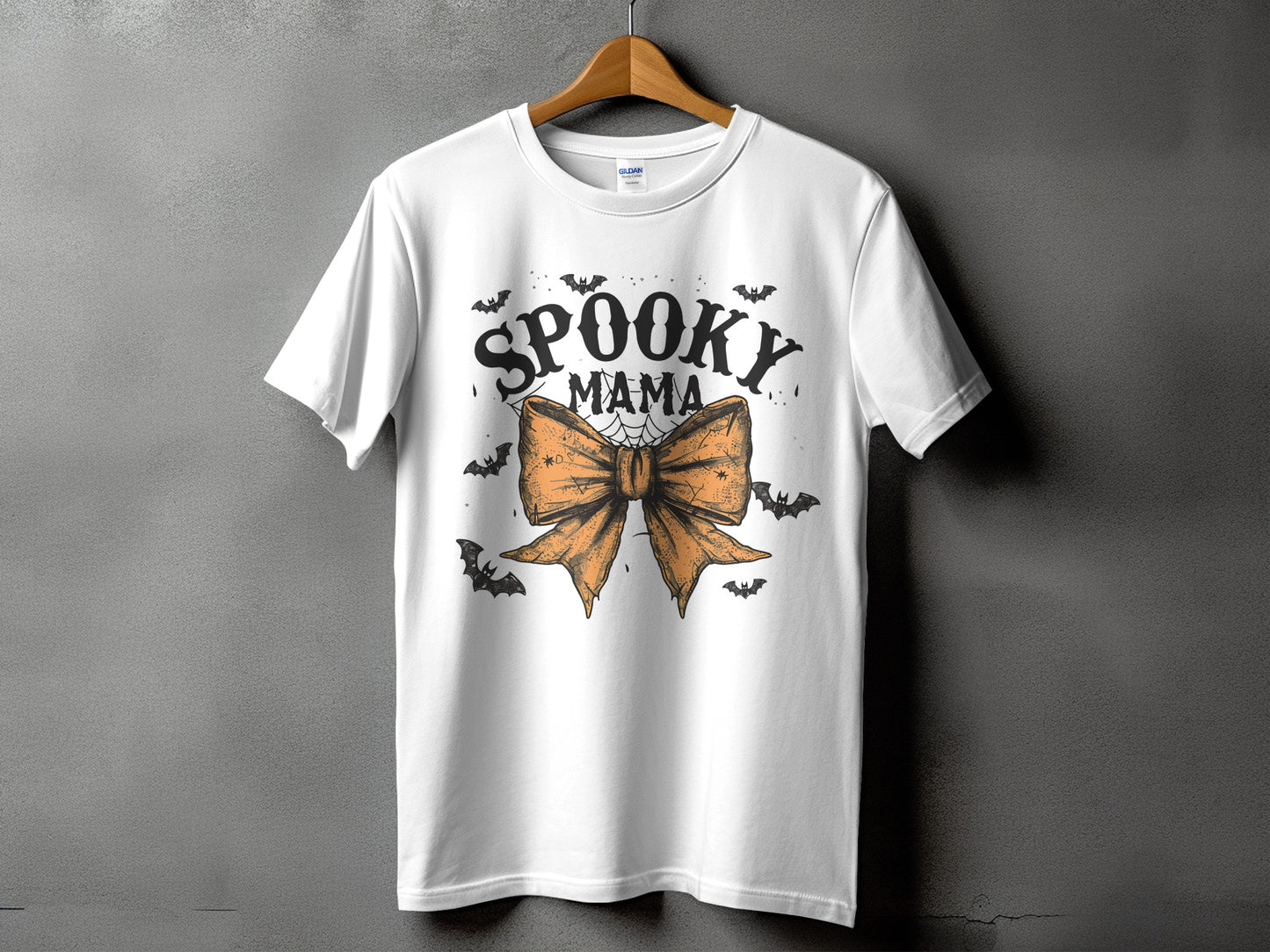 White t-shirt with "Spooky Mama" text and orange bow graphic with bats.