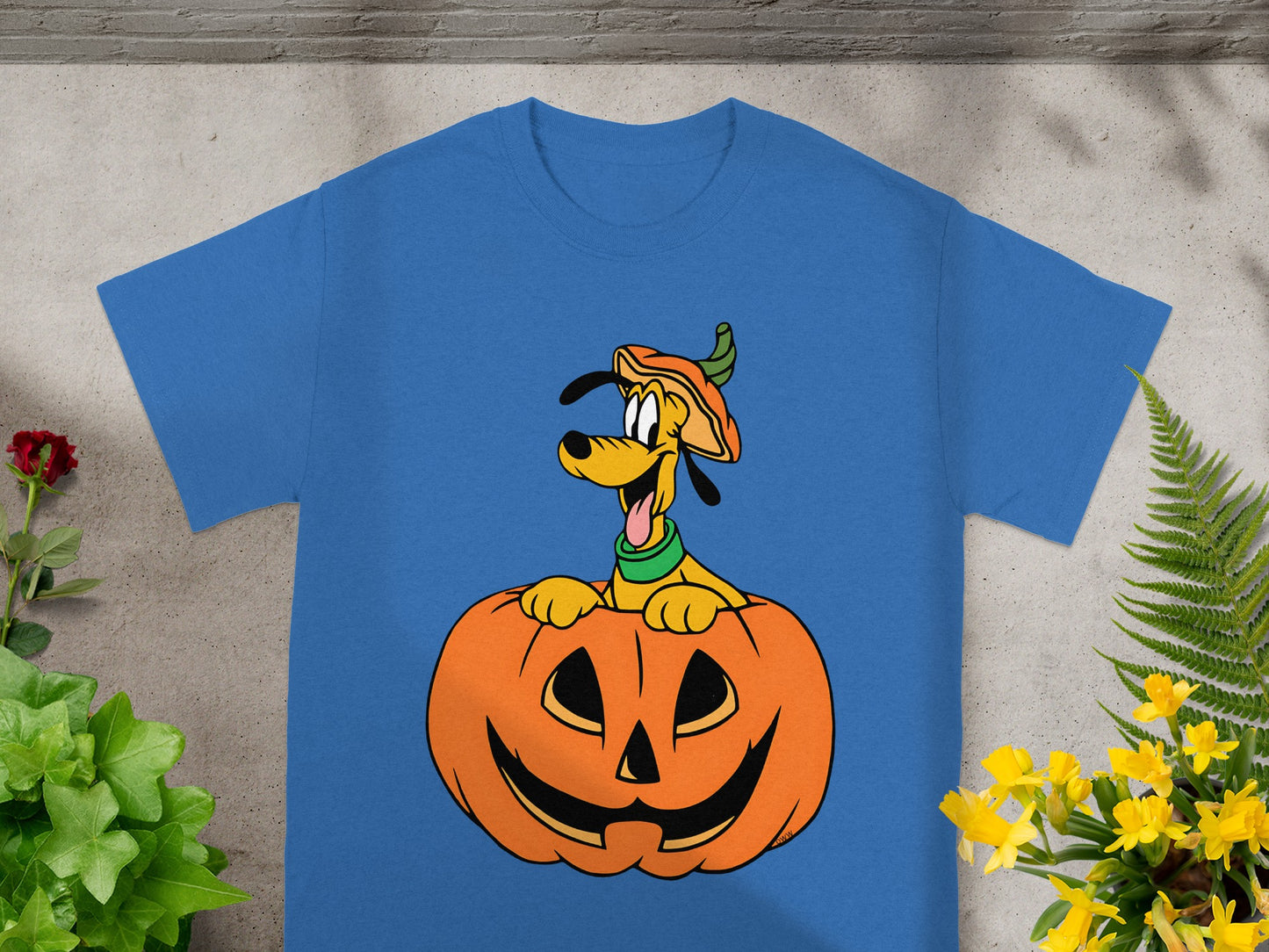 Pluto wearing a pumpkin hat peeking from inside a carved jack-o'-lantern.