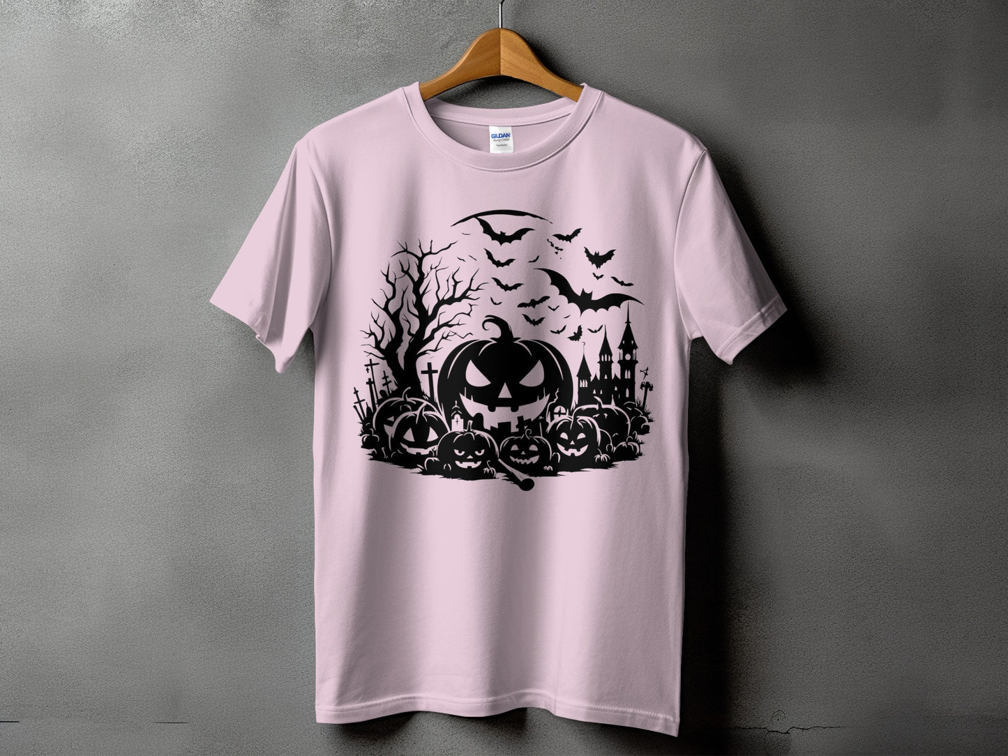 Pink t-shirt with a black Halloween graphic featuring pumpkins, bats, and a haunted castle.