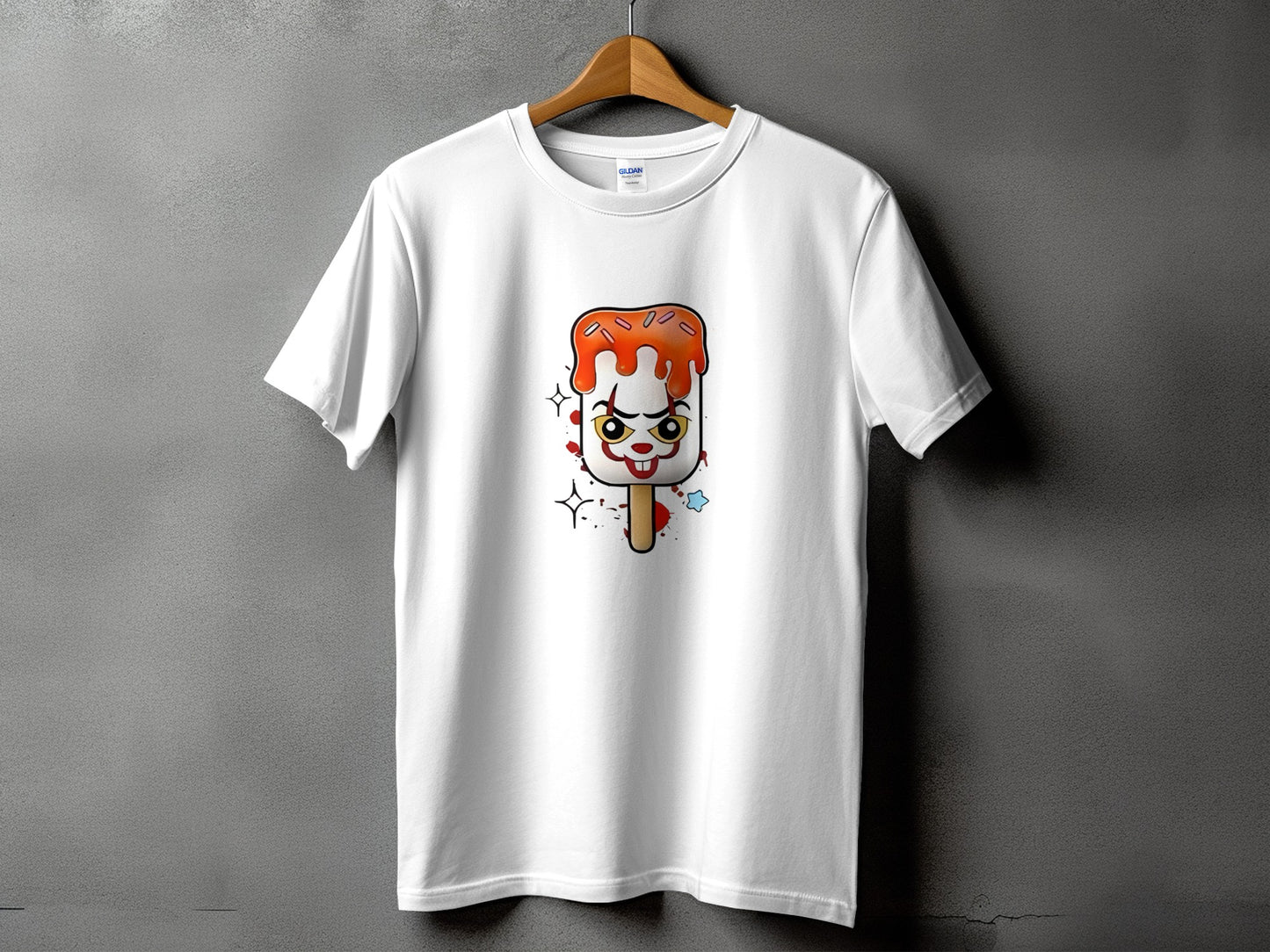 White t-shirt with a cartoon popsicle with clown face and orange icing design.