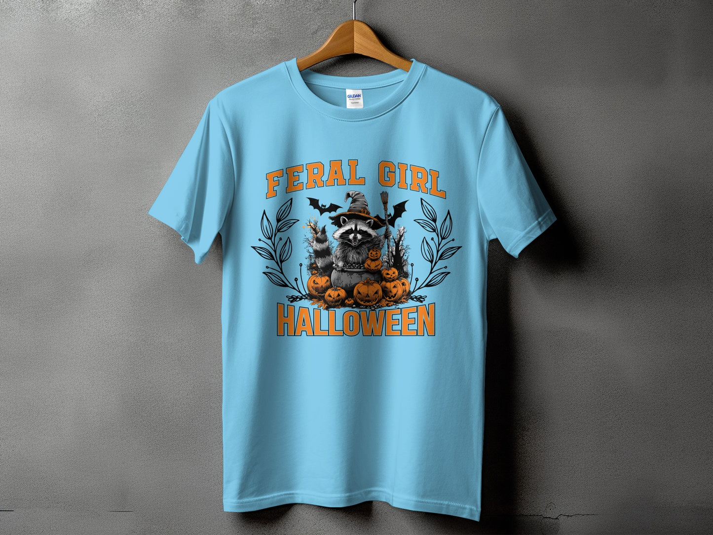 Light blue t-shirt with "FERAL GIRL" and Halloween raccoon graphic.