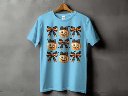 Light blue t-shirt with a pattern of Halloween pumpkins and black and orange bows.