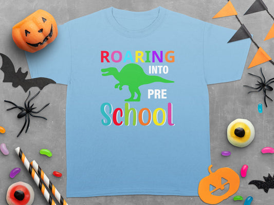 Light blue t-shirt with green dinosaur and "Roaring Into Pre School" text.