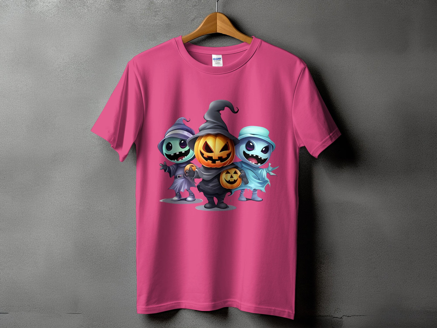 Pink t-shirt with three cartoon Halloween characters: witch, jack-o-lantern, and ghost.