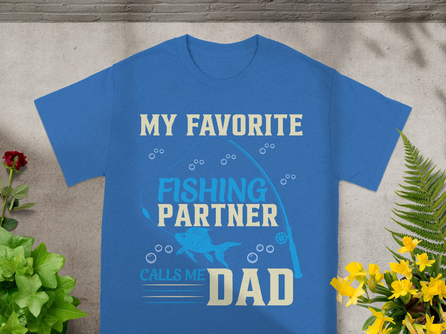 Blue t-shirt with "My Favorite Fishing Partner Calls Me Dad" text and fishing graphics.